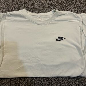Three Nike T-shirts. Pale green, tan, blue.